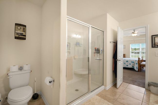 Full bath with ensuite bath, a shower stall, tile patterned floors, and toilet | Image 10
