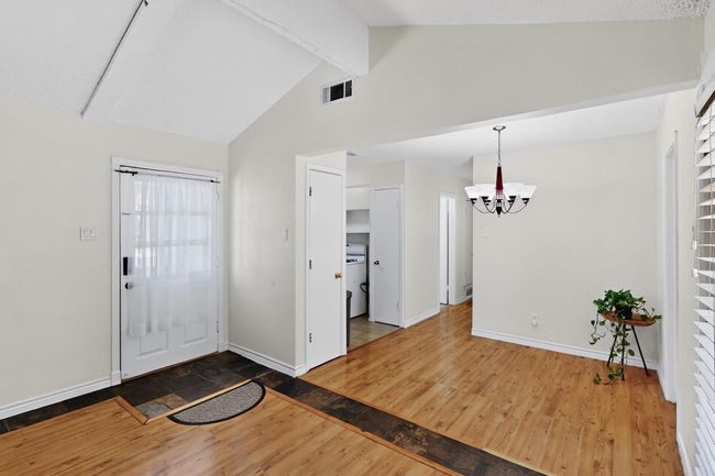 Foyer with a chandelier, beam ceiling, wood finished floors, and high vaulted ceiling | Image 21