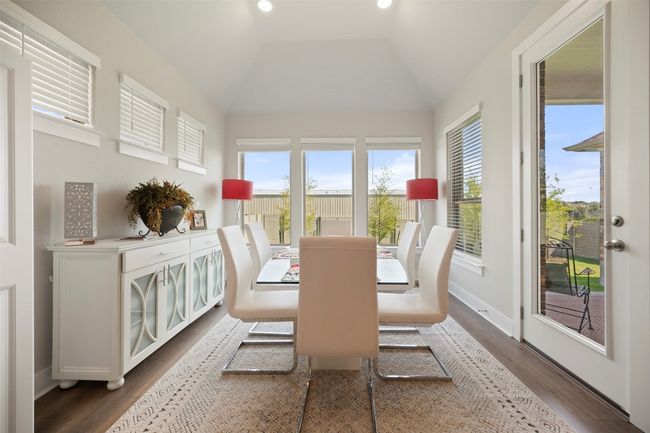 Dining space featuring dark wood finished floors and vaulted ceiling | Image 21