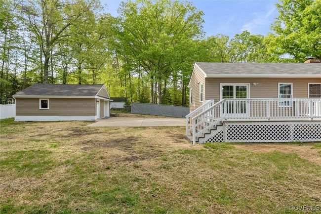 View of yard with a deck, fence, an outdoor structure, and a garage | Image 38