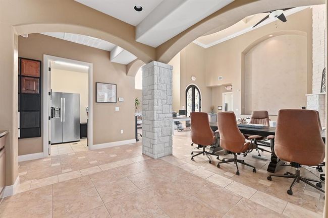Dining space with baseboards, visible vents, arched walkways, ceiling fan, and ornate columns | Image 11