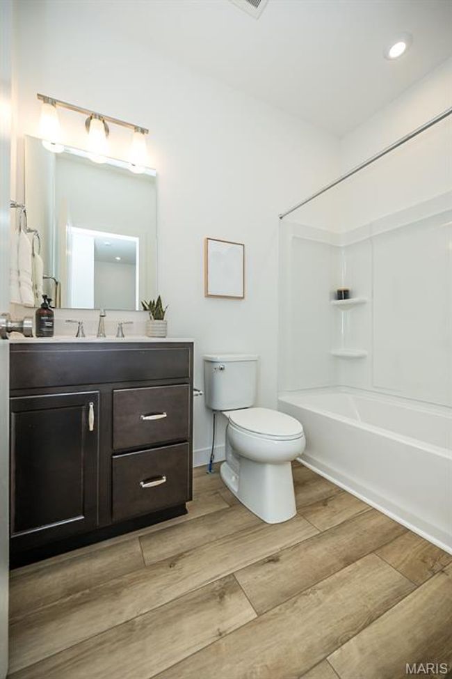 Bathroom featuring vanity, wood finished floors, and washtub / shower combination | Image 29