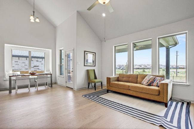 Living room with plenty of natural light, wood finished floors, high vaulted ceiling, and a ceiling fan | Image 15