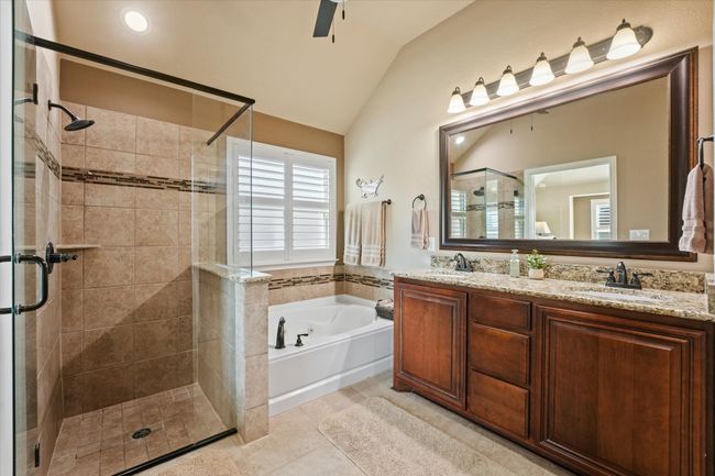 Bathroom with vaulted ceiling, a sink, a stall shower, a bath, and double vanity | Image 23