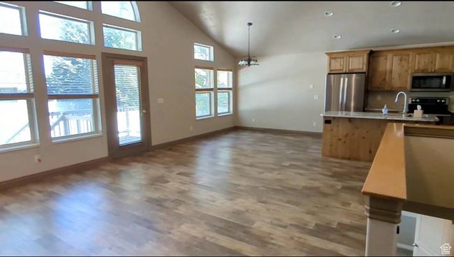 Kitchen with appliances with stainless steel finishes, light wood-style floors, baseboards, a sink, and light countertops | Image 13