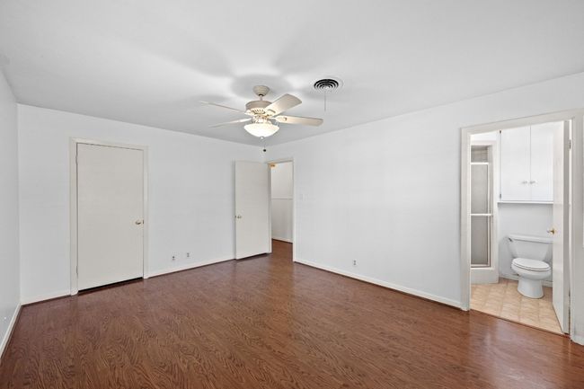 Bedroom with wood floors, baseboards, and ensuite bathroom | Image 17