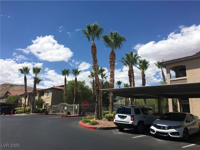 Covered parking lot featuring a gate and a residential view | Image 14