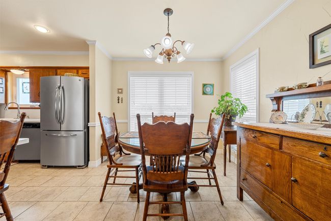 Dining room featuring a chandelier, crown molding, and light tile patterned floors | Image 8