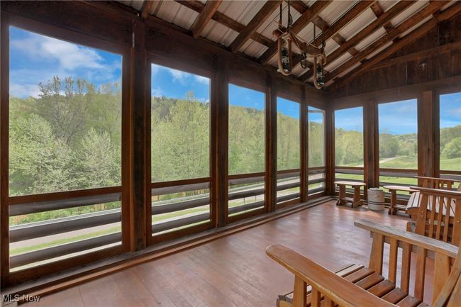 Sunroom / solarium featuring hardwood / wood-style floors, beam ceiling, and high vaulted ceiling | Image 27