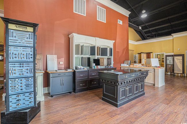 Room with a towering ceiling, wood finished floors, and dark cabinets | Image 14