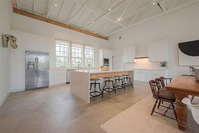 View of island with four chairs and kitchen | Image 7