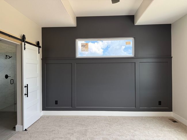 Interior space featuring a barn door, a decorative wall, carpet floors, and a wainscoted wall | Image 8