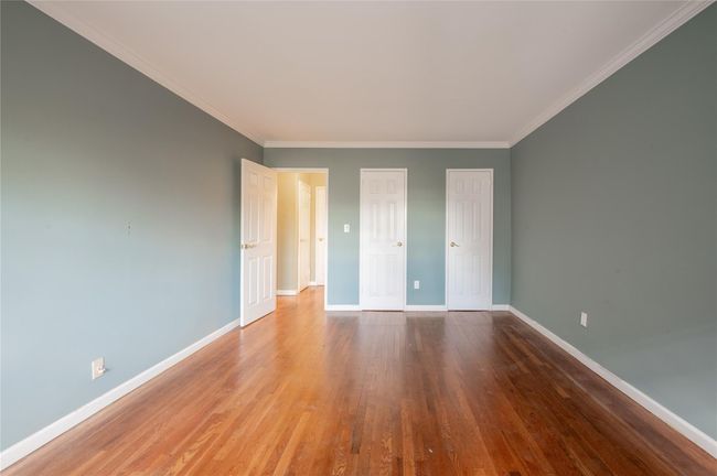 Unfurnished room featuring crown molding, baseboards, and wood finished floors | Image 28