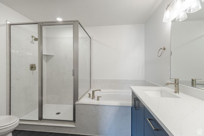 Full bathroom with toilet, vanity, a garden tub, and a marble finish shower | Image 10