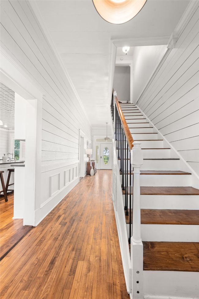 Staircase with hardwood / wood-style flooring and ornamental molding | Image 6