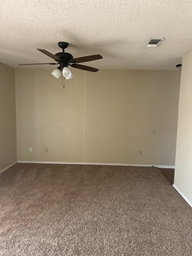 Carpeted empty room featuring a ceiling fan and a textured ceiling | Image 5