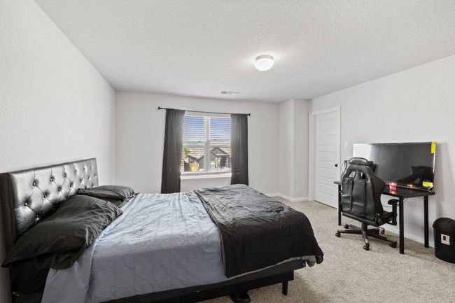 Bedroom featuring a textured ceiling, visible vents, carpet flooring, and baseboards | Image 20