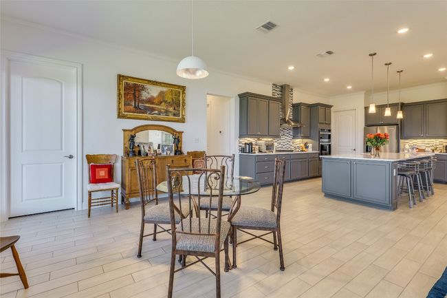 Dining room featuring wood finish floors, crown molding, and recessed lighting | Image 9