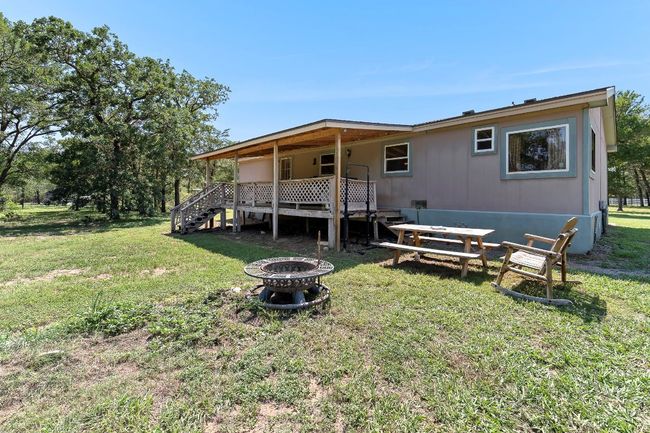 Rear view of property featuring a fire pit, stairs, covered deck | Image 21