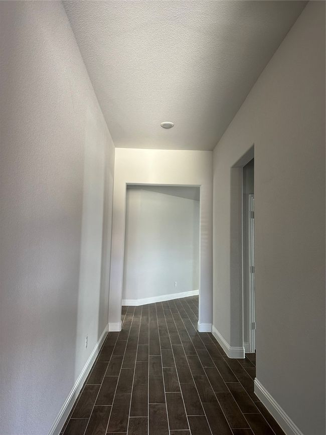 Hallway with wood finish floors and a textured ceiling | Image 9