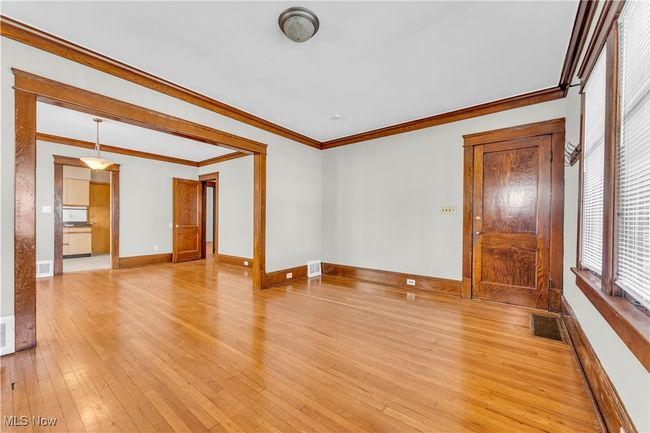 Spare room featuring ornamental molding, light wood finished floors, visible vents, and baseboards | Image 7