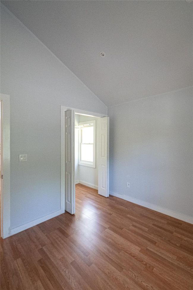Unfurnished room with lofted ceiling and wood finished floors | Image 5