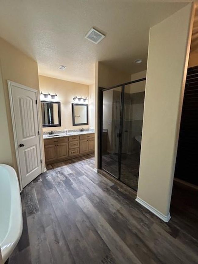 Bathroom with hardwood / wood-style floors, shower primary bathroom with dual vanity | Image 11