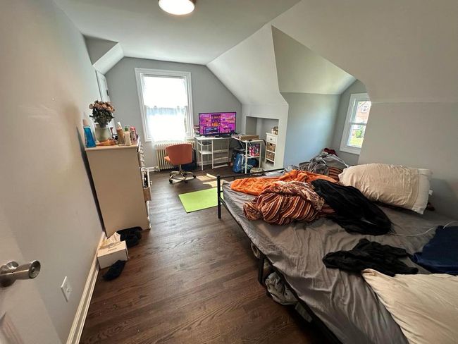 Bedroom with vaulted ceiling, wood finished floors, multiple windows, and baseboards | Image 12