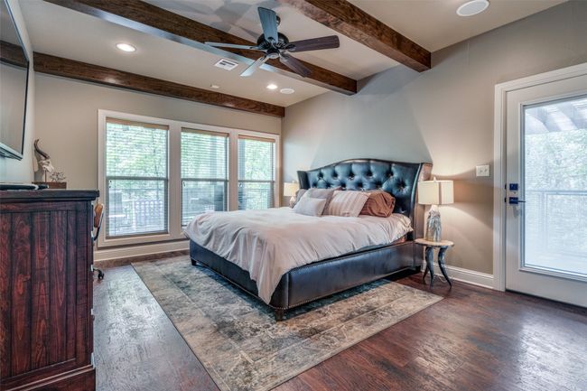 Bedroom featuring dark wood-type flooring, beam ceiling, and ceiling fan | Image 12