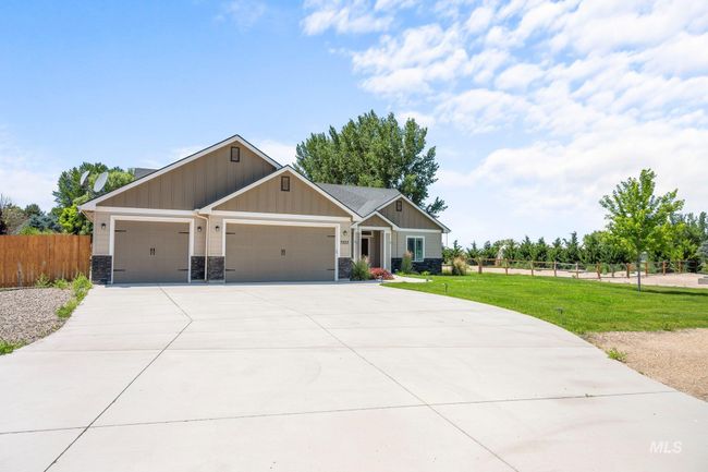 Craftsman-style house with a garage, driveway, board and batten siding, and stone siding | Image 4