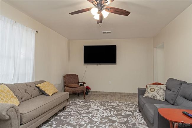 Living area with light wood-type flooring and a ceiling fan | Image 9