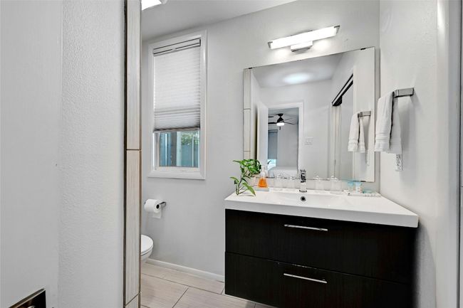 A charming vanity and tile flooring grace the primary bathroom. | Image 19