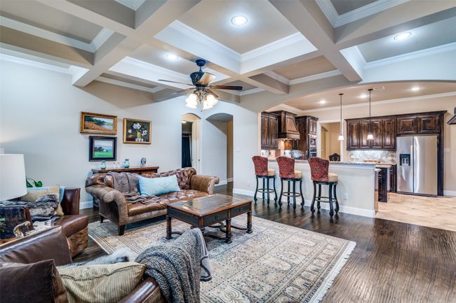 The living and kitchen areas feature raised ceilings tastefully trimmed with crown molding and designed archway looking into the large chefs kitchen. Guests will enjoy sitting at the bar area. | Image 11