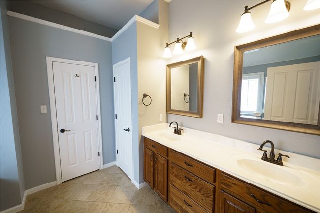 Bathroom featuring double vanity, baseboards, and tile patterned flooring | Image 17