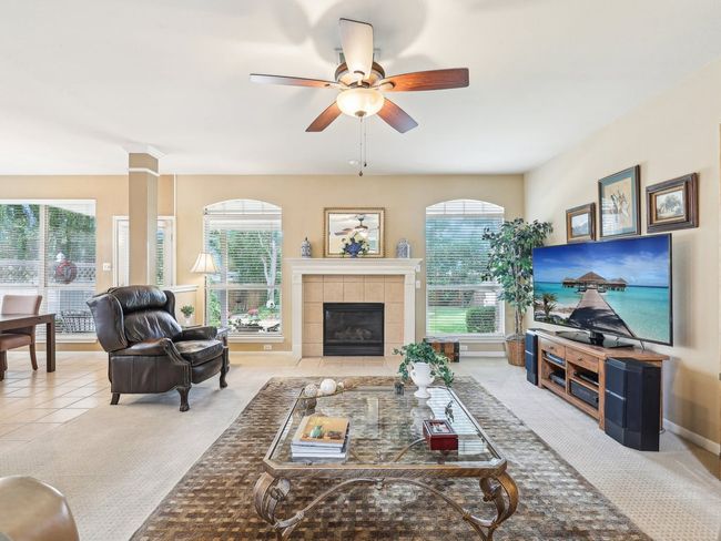 Living room featuring plenty of natural light, ceiling fan, a tile fireplace, and tile patterned flooring | Image 7