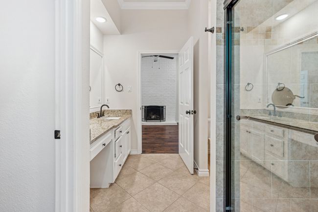 Bathroom featuring vanity, tile patterned flooring, a stall shower, and crown molding | Image 17