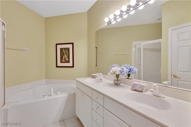 Primary Bathroom featuring a shower stall, a bath, double vanity, and tile patterned floors | Image 26