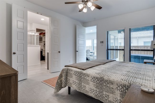 Downstairs MasterBedroom featuring light carpet, a walk in closet, a ceiling fan, and recessed lighting | Image 21