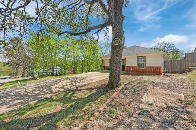 View of front of property featuring driveway, fence, and a shingled roof | Image 6