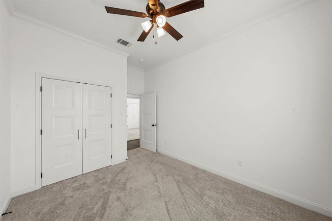 Unfurnished bedroom featuring carpet flooring, crown molding, a closet, and ceiling fan | Image 25