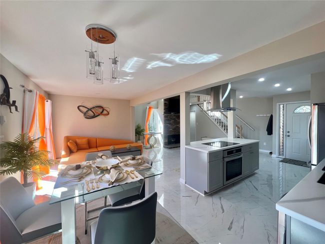 Kitchen featuring open floor plan, stainless steel appliances, light countertops, and exhaust hood | Image 30