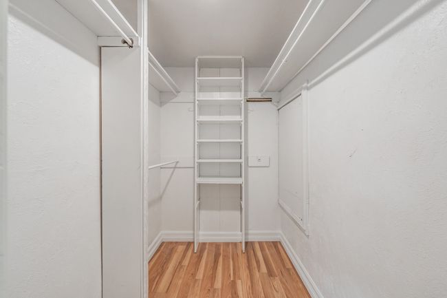 Spacious closet with light wood finished floors | Image 19