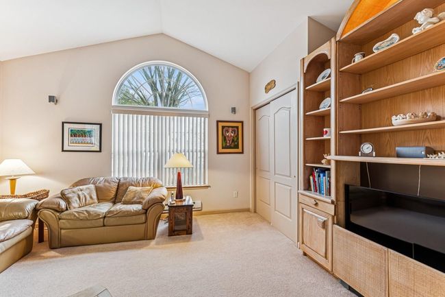 Living room with light carpet, baseboards, and vaulted ceiling | Image 25