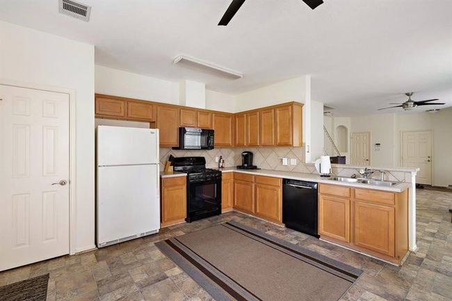 Well-designed open kitchen that flows into a spacious living room for a harmonious living space. | Image 10