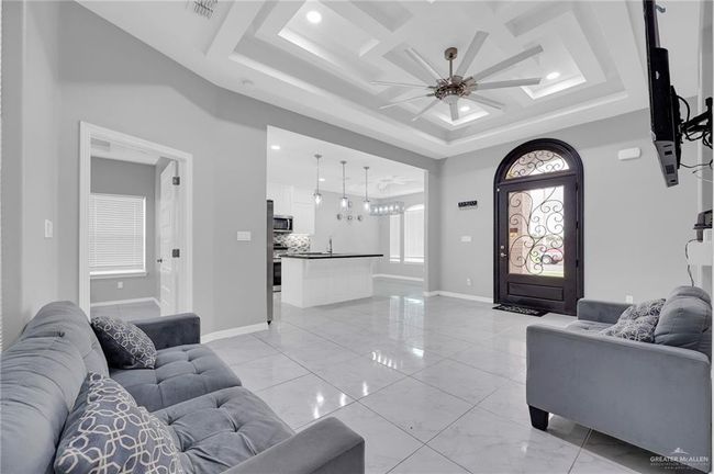 Living area with a ceiling fan, recessed lighting, a tray ceiling, and light marble finish floors | Image 6