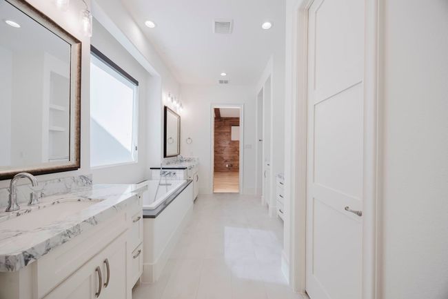 Bathroom featuring two vanities, a garden tub, recessed lighting, and light tile patterned floors | Image 20