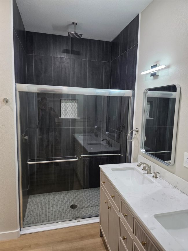 Full bathroom with wood finished floors, double vanity, and a shower stall | Image 7