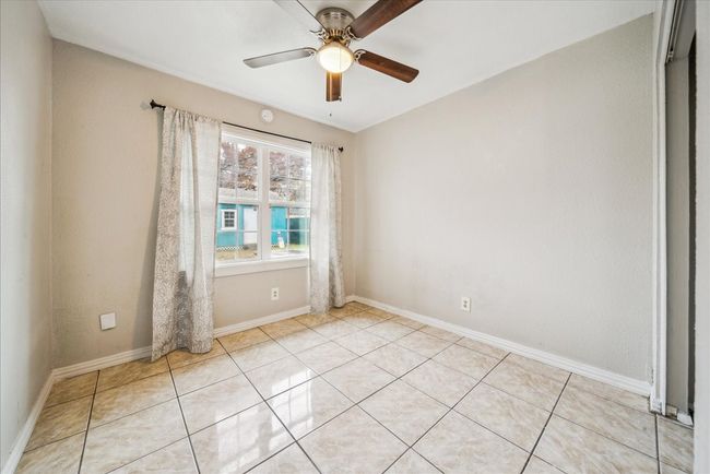 Empty room with ceiling fan and light tile patterned flooring | Image 17