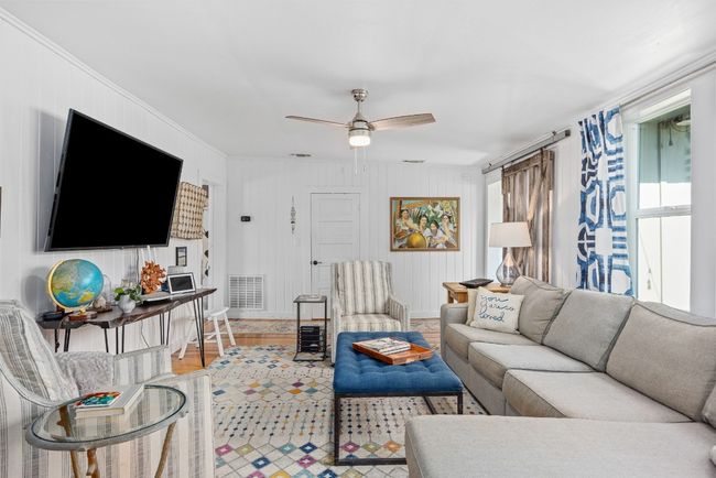 Living room featuring a ceiling fan, ornamental molding, and light wood-type flooring | Image 10