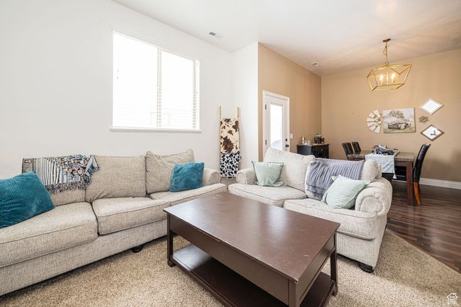 Living area with baseboards, visible vents, an inviting chandelier, and light wood-style floors | Image 9